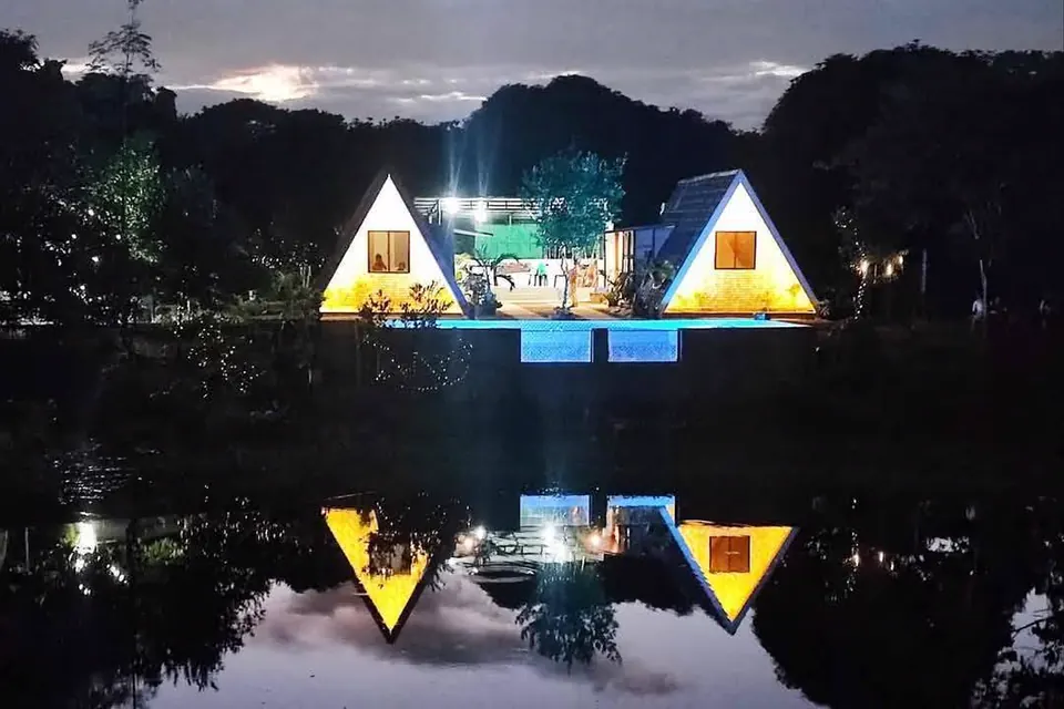 Both casitas lit at night and mirrored in the pool