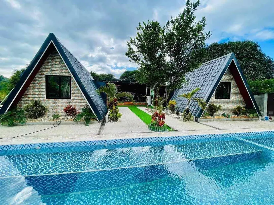 The two A-frame casitas seen across the mosaic-tiled pool