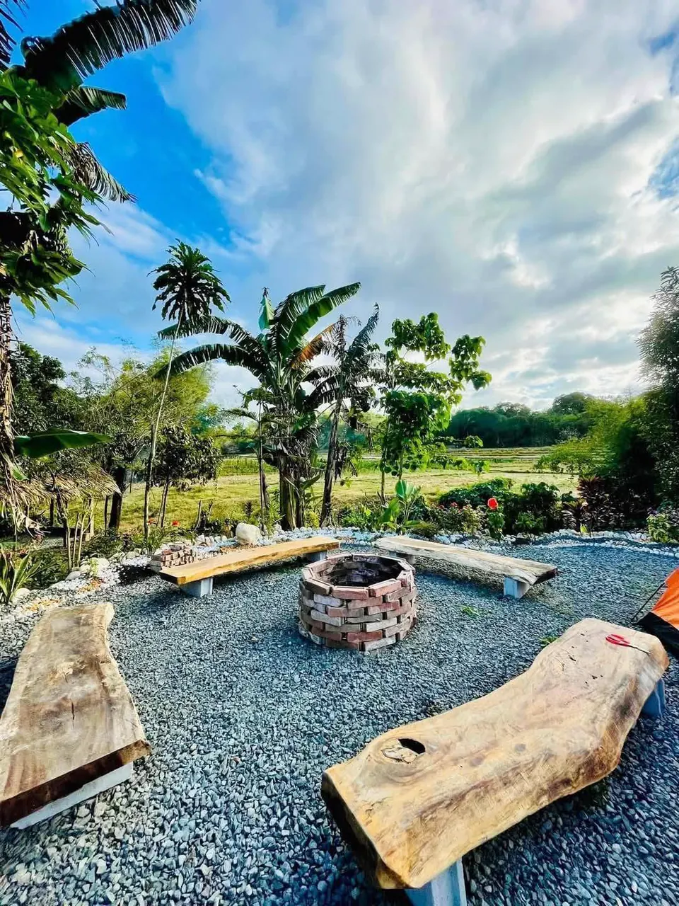 Stone bonfire pit ringed by carved log benches