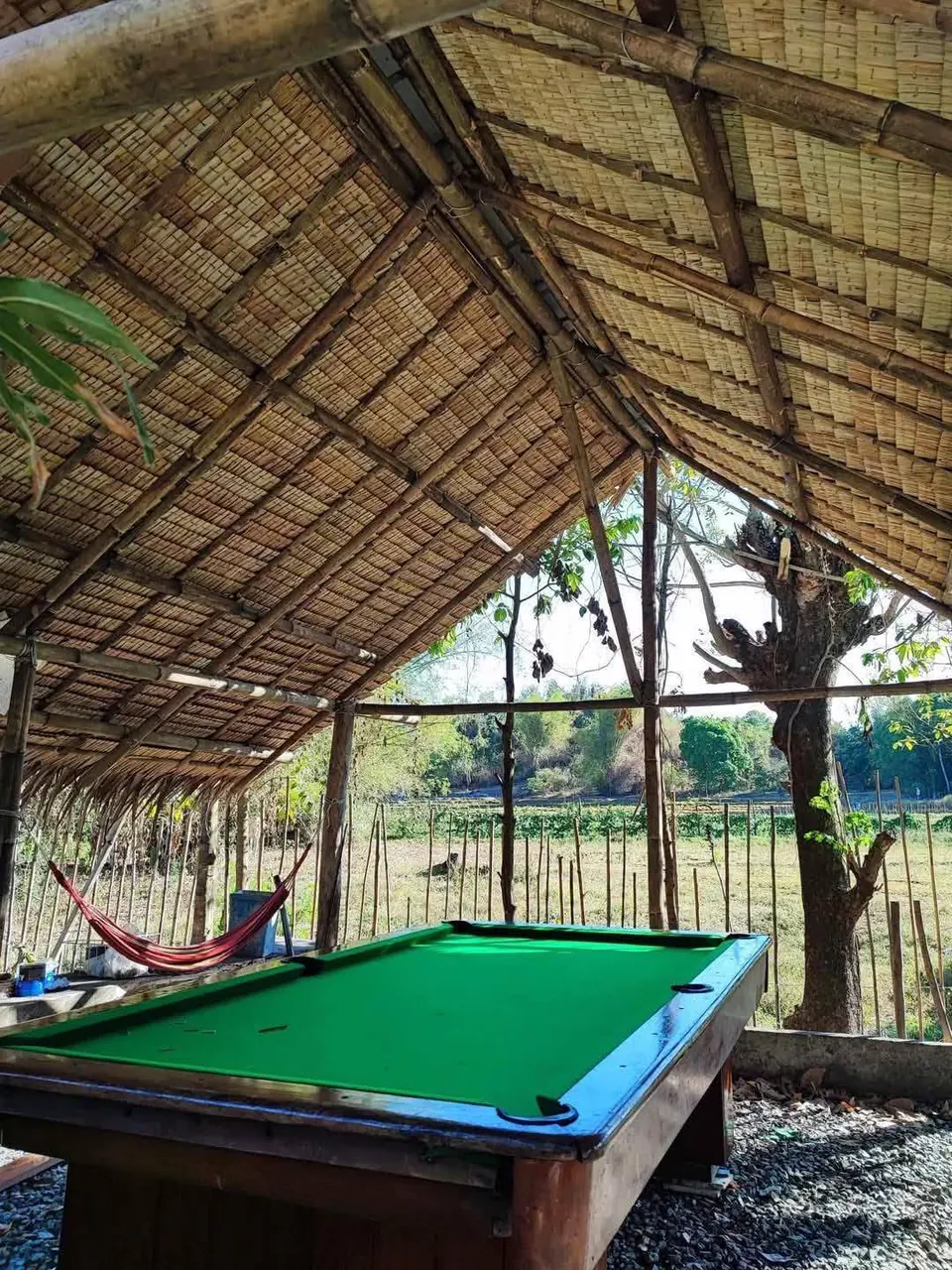 Billiard table and hammock under the nipa-roofed kubo