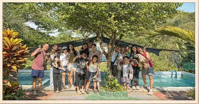 A large family group by the pool under the trees